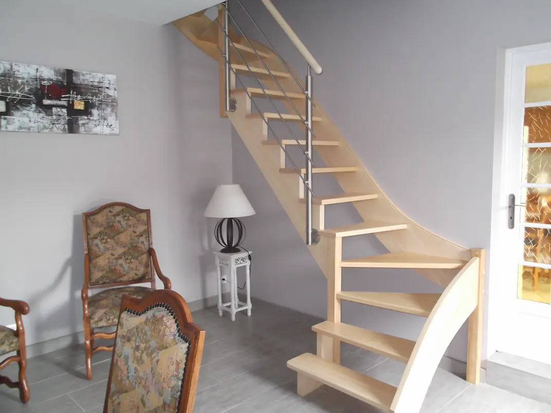 Escalier contemporain en bois clair avec garde-corps design en inox brossé.