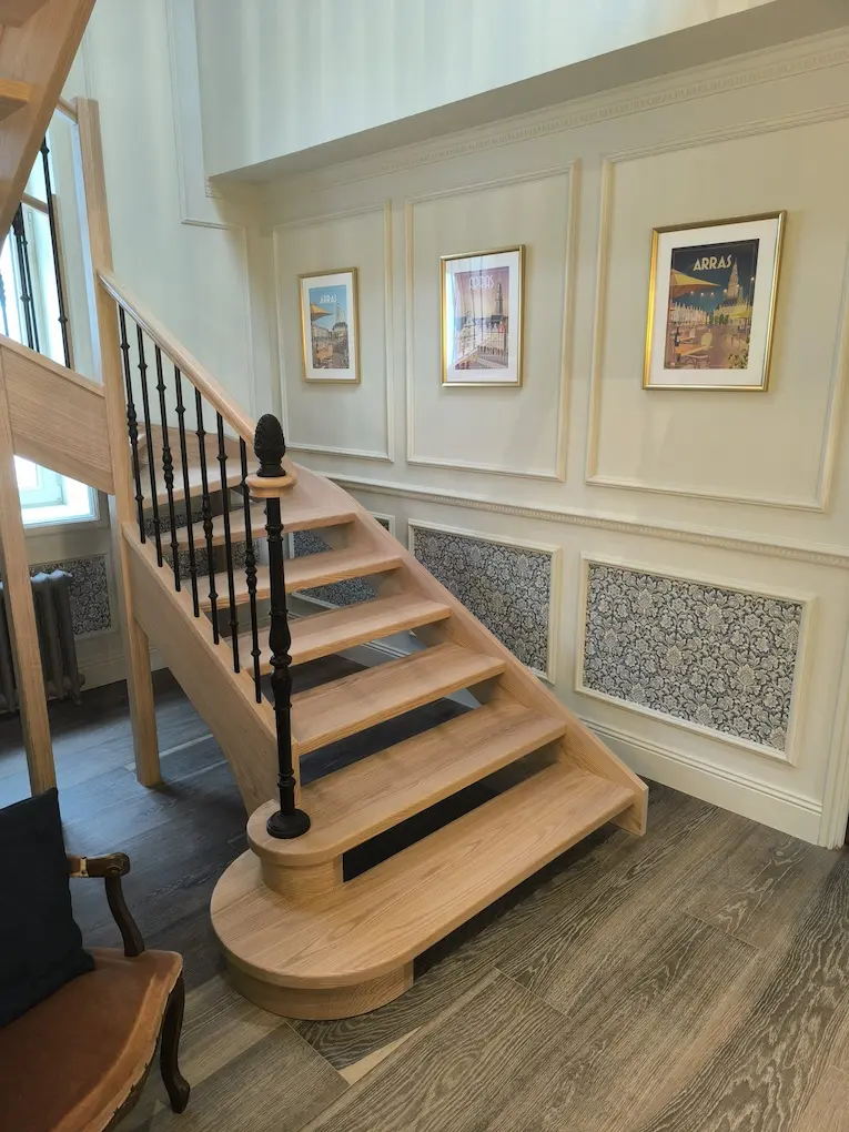 Escalier traditionnel en bois massif avec rampe artisanale et marches larges.